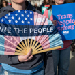 Trans Pride flag with ACLU sign in back